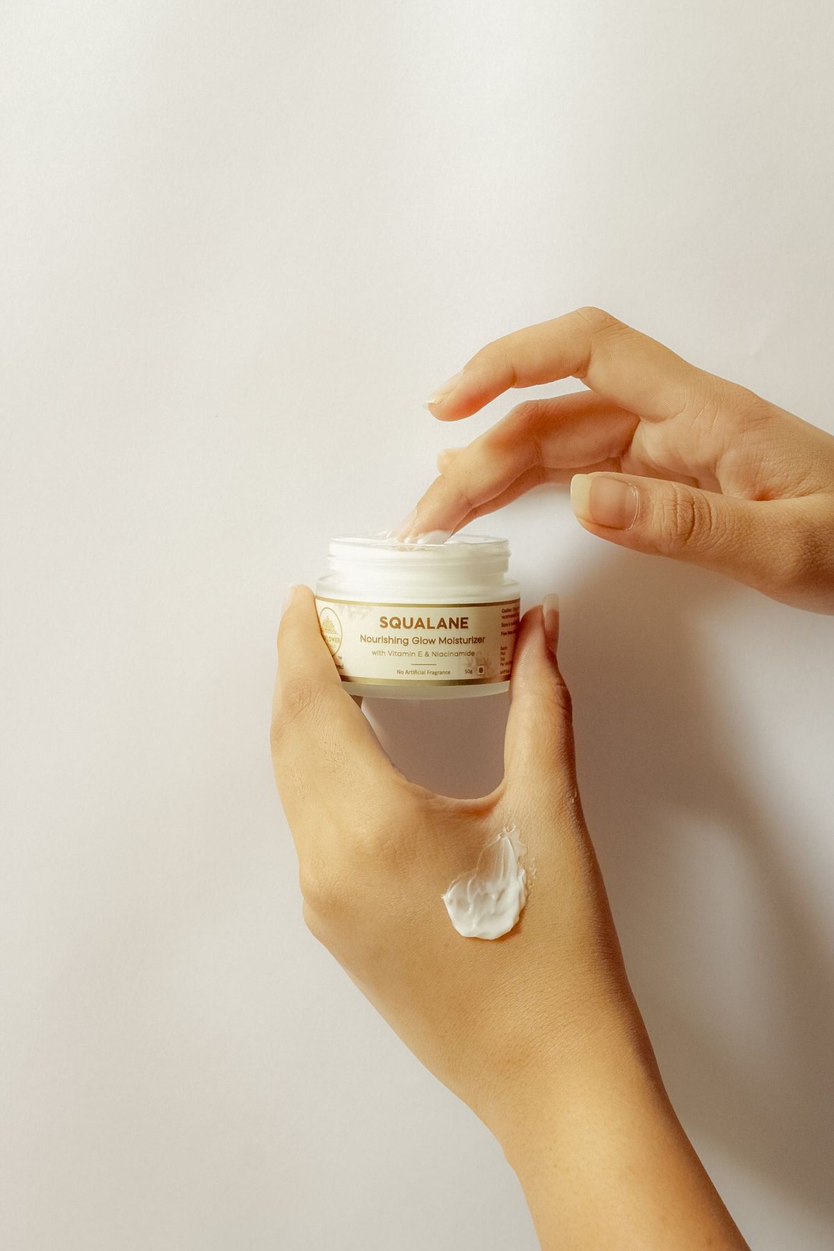 Manos aplicando crema de escualano