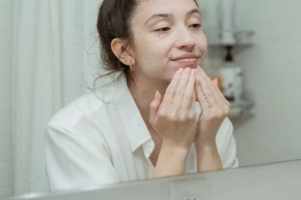 Mujer haciendo masaje facial con crema