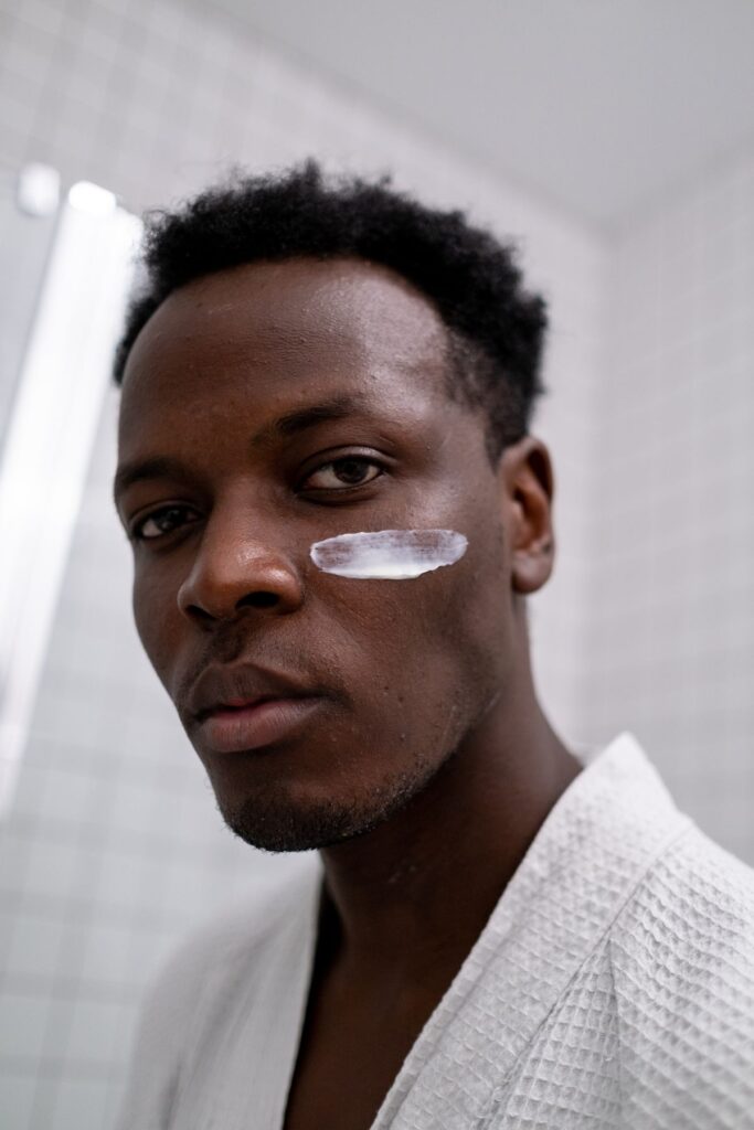 Hombre con crema facial en el baño